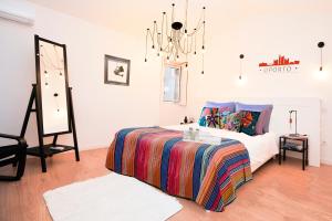 ein Schlafzimmer mit einem Bett mit einer bunten Decke in der Unterkunft 137 Private family home -8 min from historic center in Vila Nova de Gaia