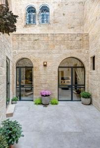 - un bâtiment en pierre avec deux grandes portes en verre dans l'établissement Old City Boutique Hotel, à Jérusalem