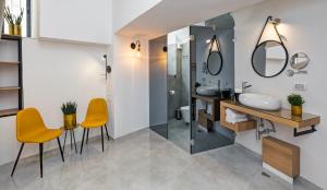 耶路撒冷Old City Boutique Hotel的一间带水槽和两把橙色椅子的浴室