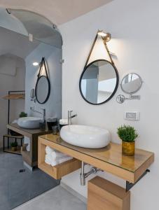 a bathroom with two sinks and two mirrors at Old City Boutique Hotel in Jerusalem