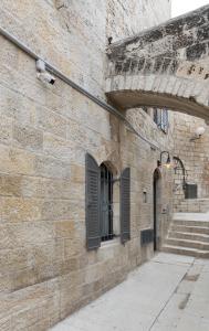 a brick wall with a door and a window and stairs at Old City Boutique Hotel in Jerusalem