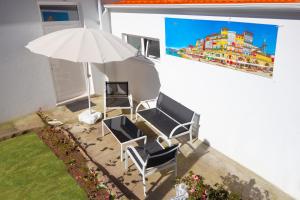 eine Terrasse mit zwei Stühlen und einem Sonnenschirm in der Unterkunft Private House Only For You 133 - 8min historicCenter in Vila Nova de Gaia