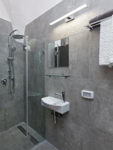 a bathroom with a sink and a glass shower at Old City Boutique Hotel in Jerusalem