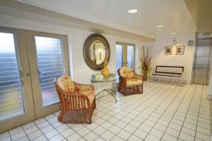 un soggiorno con 2 sedie e uno specchio di Sea Shore 41 Private Studio in Waikiki, 1 Block to Beach a Honolulu