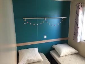 ヴィック・ラ・ガルディオルにあるTropical Bungalow 1の青い壁の客室で、ベッド2台が備わります。