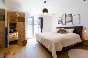 1 dormitorio con 1 cama grande y suelo de madera en AD FONTES Suite mit Bergblick & Sauna en Übersee