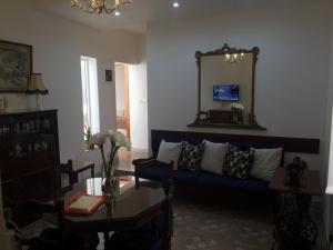 a living room with a blue couch and a table at Rose Building Apartment in Cospicua