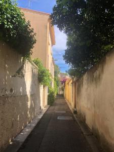 an empty alley way between two buildings with trees at Studio Vieil Antibes - Saint Antoine in Antibes