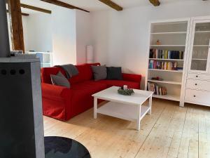 sala de estar con sofá rojo y mesa blanca en Stieg 1, en Quedlinburg
