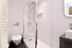 a white bathroom with a shower and a toilet at La Petite Terrasse du Centre in Colmar