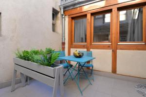 a table and a bench on a balcony with a plant at La Petite Terrasse du Centre in Colmar