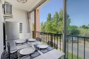 une salle à manger avec une table et un balcon dans l'établissement appartement T2 climatisé avec piscine secteur richelieu, au Cap d'Agde