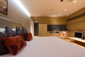 a bedroom with a large bed and a kitchen at Koharu Resort Hotel & Suites in Hakuba