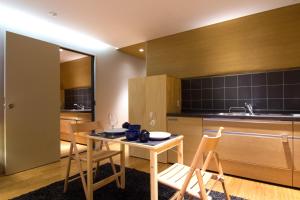 a kitchen with a table and chairs in a room at Koharu Resort Hotel & Suites in Hakuba