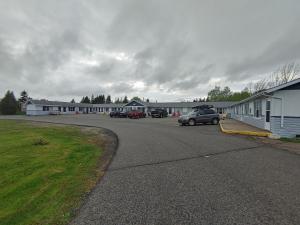 a parking lot with cars parked in front of a building at Highland Motel in North Sydney