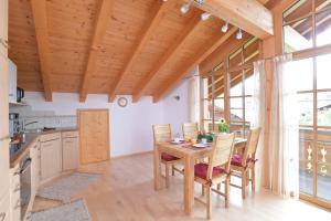 uma cozinha e sala de jantar com uma mesa de madeira e cadeiras em AlpStern Ferienwohnung em Oberstdorf