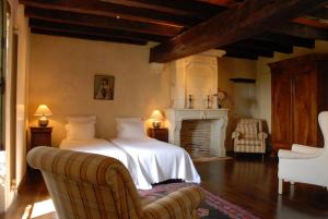 a bedroom with a white bed and a fireplace at Chambres d'Hôtes La Bastide des Trémières in Saint-Antoine-de-Breuilh +86 photos
