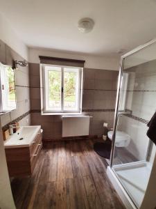 La salle de bains est pourvue d'une baignoire, d'un lavabo et d'une douche. dans l'établissement Apartmán Wake, à Česká Lípa