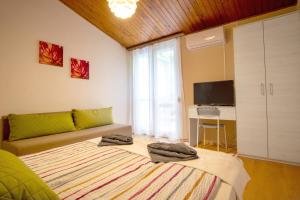 a living room with a bed and a tv at Nyaraló Apartman in Siófok
