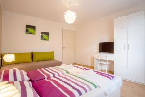 a living room with a bed and a tv at Nyaraló Apartman in Siófok