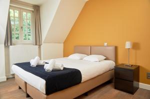 a bedroom with a large bed with white pillows at De Statie in Brecht