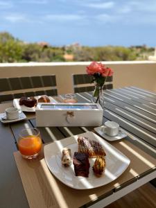 a table with a plate of food and orange juice at La Guitgia Rooms in Lampedusa
