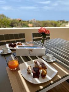 una mesa con un plato de comida y zumo de naranja en La Guitgia Rooms en Lampedusa