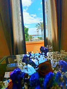 una ventana con un ramo de flores azules en una habitación en La Cueva del Bounty, en Puerto del Rosario