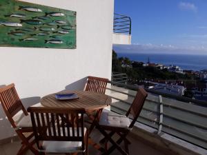 a table and chairs on a balcony with a painting at See to Sea in Ericeira