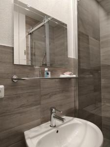 ein Bad mit einem Waschbecken und einem Spiegel in der Unterkunft Bed and Breakfast Am Knittenberg in Winterberg