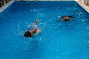 Dos personas están nadando en una piscina en Hotel Princi i Vogel, en Velipojë