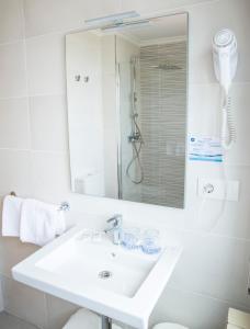 un bagno bianco con lavandino e doccia di Hotel Duna a Portonovo Altre 54 foto