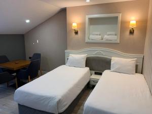 White Golden Suite Hotel في طرابزون: غرفة بسريرين وطاولة ومرآة