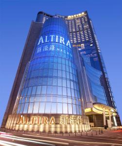um edifício de vidro alto com um sinal nele em Altira Macau em Macau