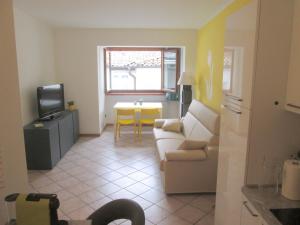 uma sala de estar com um sofá, uma televisão e uma mesa em Lady Tulip - monolocale em Trento