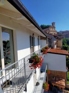Un balcón de una casa con flores. en B&B Madonna degli Airali en Vezza d'Alba