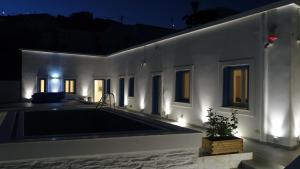 a swimming pool in the middle of a house at night at Andoni's House in Pitrofós