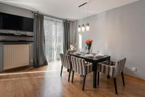 jadalnia z czarnym stołem i krzesłami w obiekcie Negroni Apartments w Krakowie