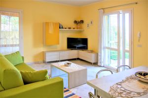 a living room with a couch and a tv at Borgo dell'Uccellaia - Turchese - Giada in Marciana Marina