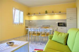 a kitchen with yellow walls and a table and chairs at Borgo dell'Uccellaia - Turchese - Giada in Marciana Marina