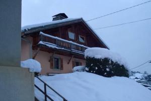 uma casa coberta de neve com uma pilha de neve em Appartement spacieux proche des télécabines et du centre ville avec jardin privé em Saint-Gervais-les-Bains