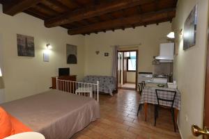 a bedroom with a bed and a table and a kitchen at Appartamento via della Posterna Spoletium in Spoleto