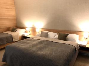 a hotel room with two beds and two lamps at Hrebienok C217 in Starý Smokovec