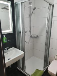 a bathroom with a shower and a sink at "Anderer´s" Gasthaus & Hotel Hohne in Hohne