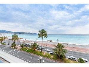 una strada accanto a una spiaggia con palme e l'oceano di Studio Carré d'Or a Nizza
