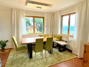 a dining room with a table and chairs and windows at Ferienhaus Karawankenblick in Wurzen