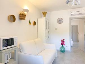 a white living room with a white couch and a tv at La Mignola in Fasano