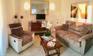a living room with two couches and a tv at GardaLake View Villa in Lazise