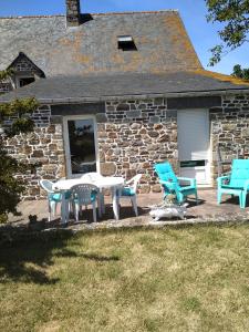 un patio con tavolo e sedie di fronte a una casa in pietra di Le Manoir de la Pichardière a Cherrueix