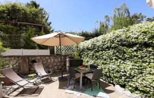 a patio with a table and chairs and an umbrella at Dreaming Sorrento Suites in Sorrento